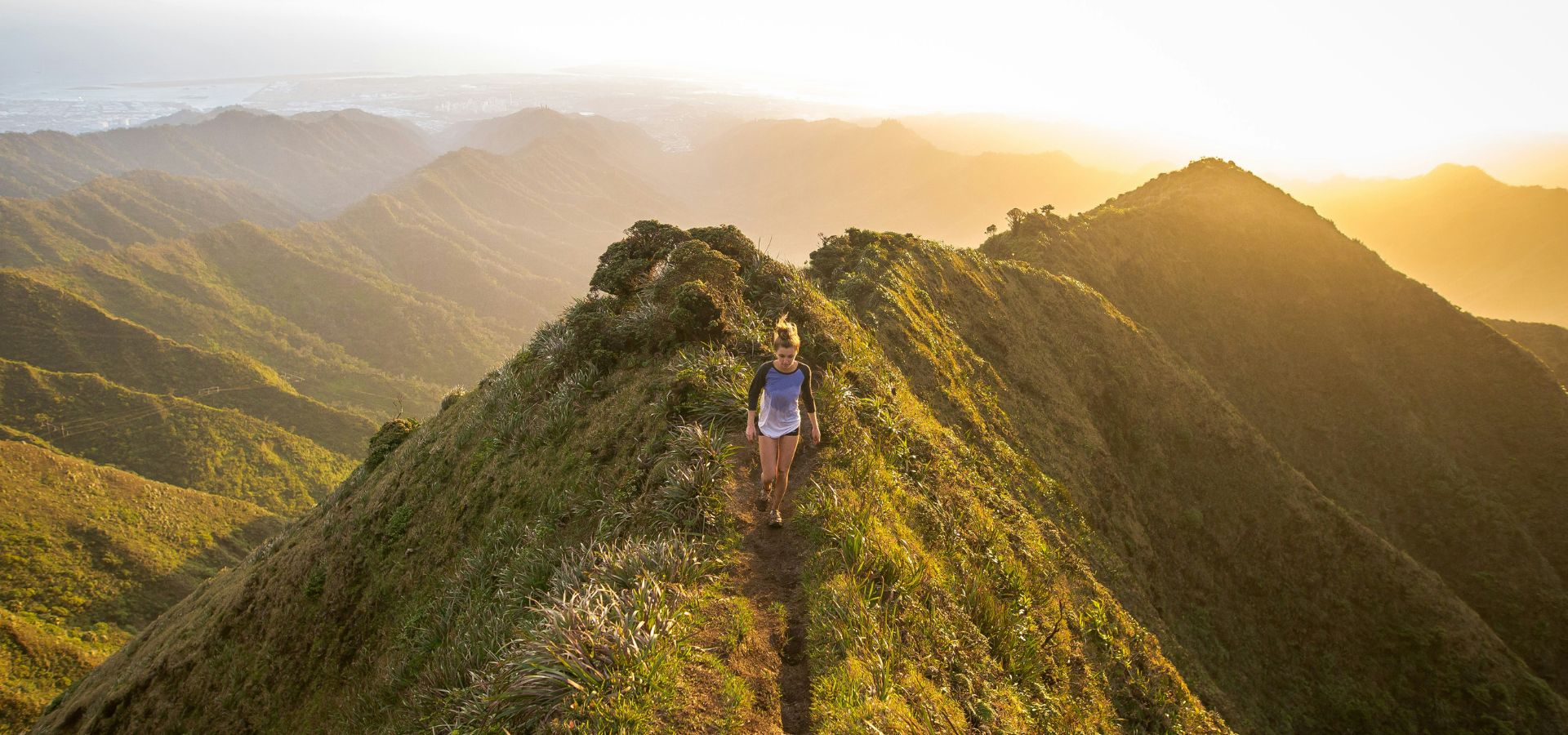Woman hiking on a mountain at sunset, protected with Squirrel’s Nut Butter – natural anti-chafe salve for hikers, prevents chafing and blisters, water-resistant, long-lasting, and skin-friendly